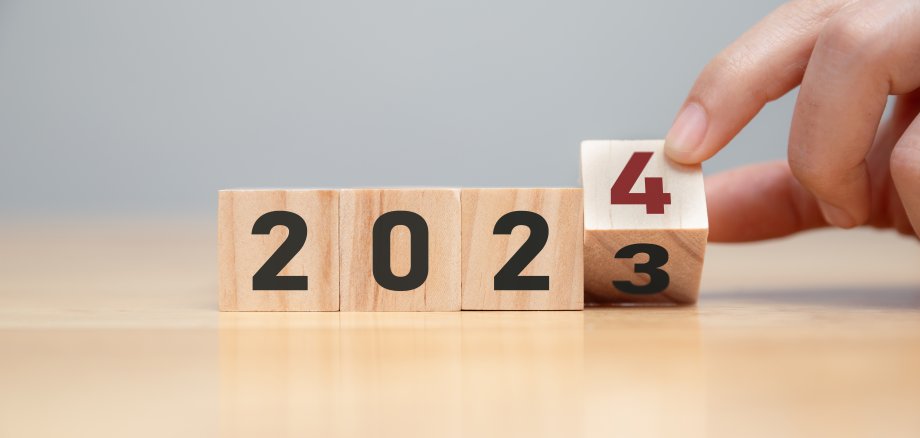 Hand of man flip wooden cube from 2023 to 2024. Hand of man flip wooden cube from 2023 to 2024.