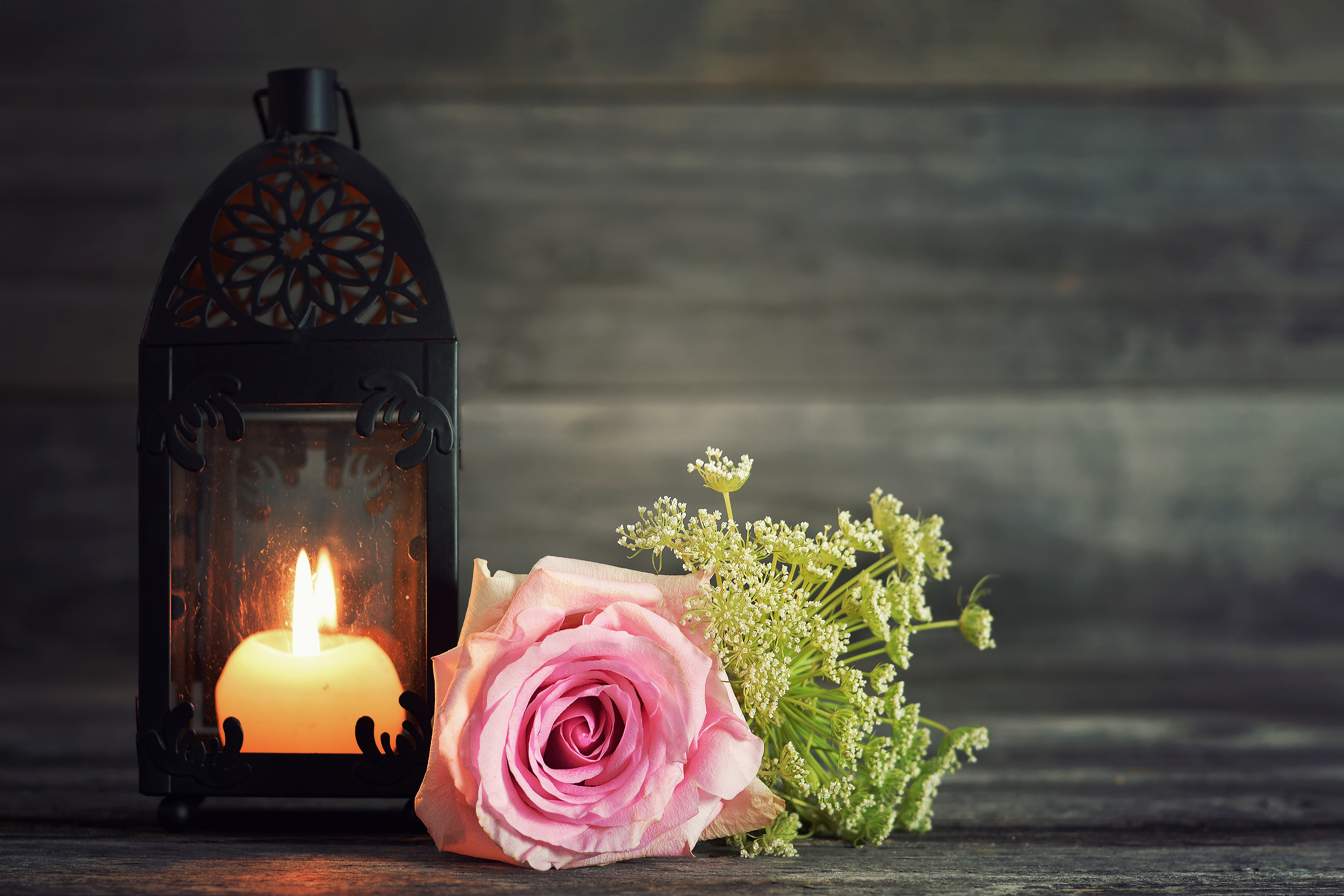 Memorial candle and flowers on wooden background