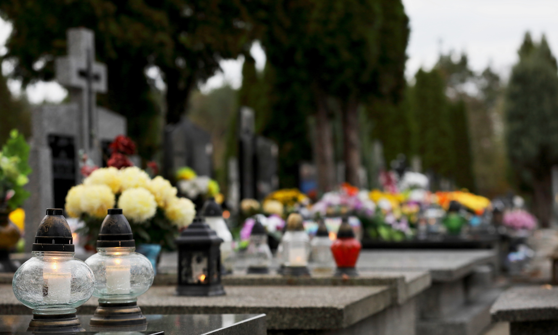 bouquet of flowers in a vase at the cemetery, candles on the gra