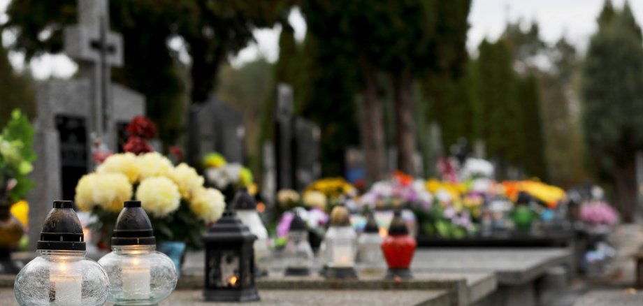 bouquet of flowers in a vase at the cemetery, candles on the gra bouquet of flowers in a vase at the cemetery, candles on the gra