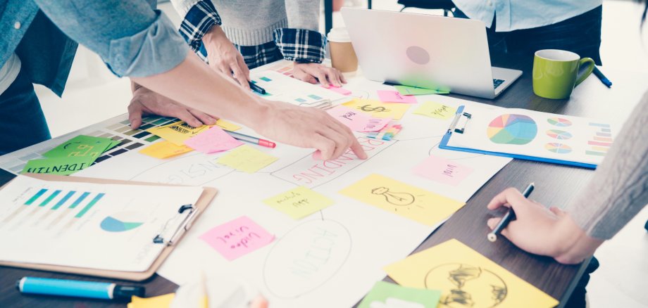 Group of casually dressed business people discussing ideas in the office. Creative professionals gathered at the meeting table for discuss the important issues of the new successful startup project.