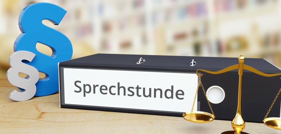 Sprechstunde – Recht/Gesetz. Ordner auf Schreibtisch mit Beschriftung neben Paragraf und Waage. Anwalt